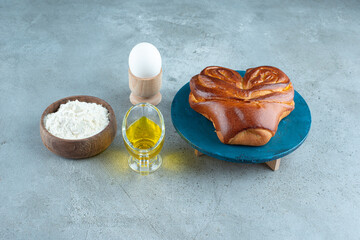 Sweet pastry, flour and olive oil on marble surface