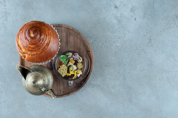 Cup of tea, teacup and pastry on wooden plate