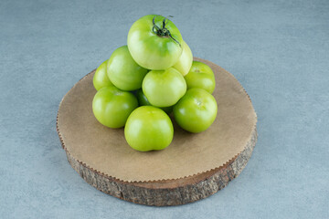 Bunch of green tomatoes on wooden piece