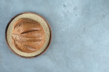 Delicious rye bun on wooden plate
