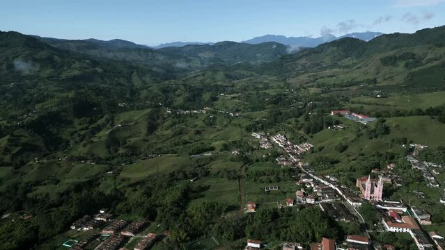 aerial view of Jerico little town in Colombia Antioquia department in andes mountains, green valley with traditional village and old church cathedral drone fly above