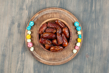 Bowl of dates and popcorns on wooden plate