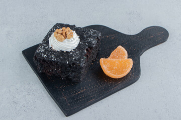 Chocolate cake and marmelades on a black board on marble background