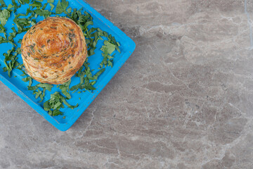 Sour gogal and parsley leaves on a blue platter on marble background