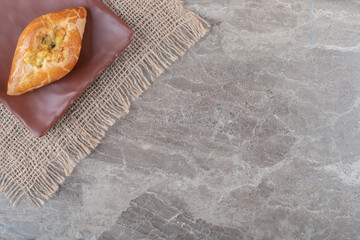 Single pide served on a platter on marble background