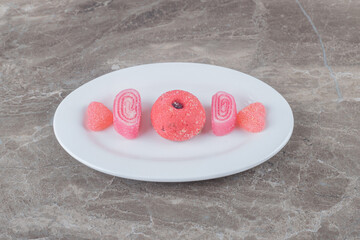 marmelades and a cookie aligned on a platter on marble background