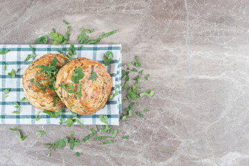 Chopped parsley leaves and sour gogals on a towel on marble background