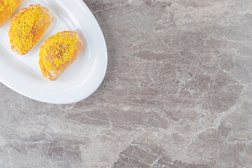Three small buns on a platter on marble background