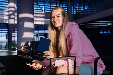 Travel happiness after the coronavirus pandemic. Young smiling woman with passports at the airport.