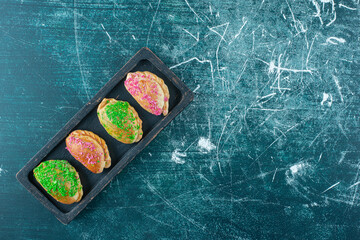 Platter on buns with various toppings on blue background