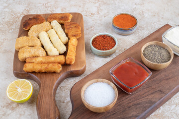 Chicken nuggets, cheese sticks and fried sausages witn variety of sauces and spices