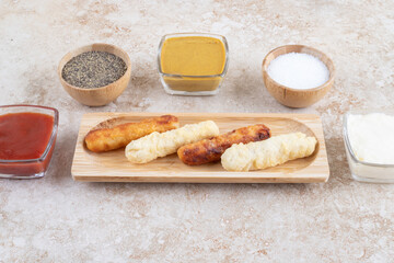 Cheese nuggets and grilled sausages with sauces