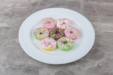 Donuts served on a white platter on marble background