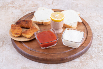 Fried chicken nuggets and toast breads with cheese served with sauces