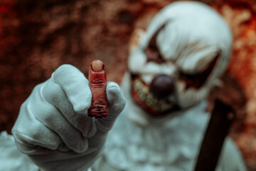 creepy evil clown shows an amputated finger