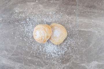 Vanilla powder and two flaky cookies on marble background