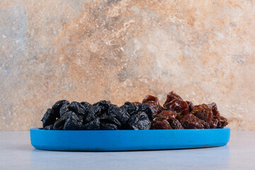 Dried cherry and plums in a blue platter