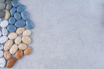 Fototapeta na wymiar Pastel color stones for crafting on concrete background