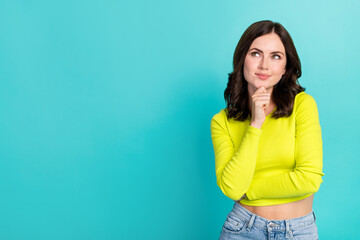 Photo of young attractive pretty nice woman hold chin minded interested looking empty space brainstorming isolated on cyan color background