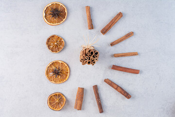 Cinnamon sticks with dry orange slices on the ground