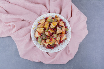 Salad with seasonal fruits and spices on concrete background