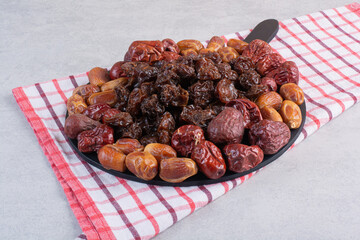 Dry fruit combination on a platter on concrete background