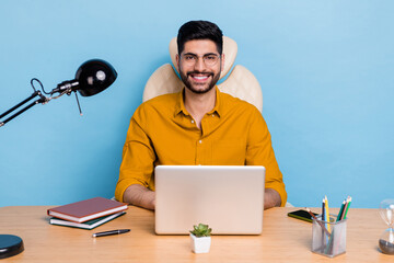 Photo of cheerful successful man desktop workstation use netbook isolated on blue color background
