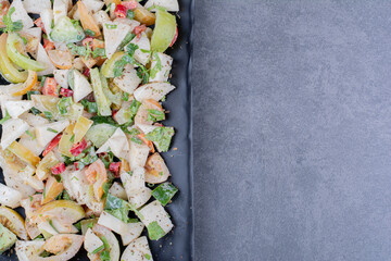 Salad with herbs and vegetables in a platter