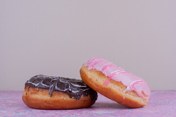 Pink and chocolate doughnut bun on a textured background