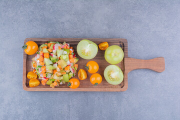 Salad with green vegetable and cherry tomatoes in woodendishes