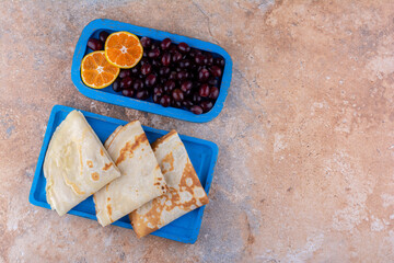 Crepes with orange slices and berries