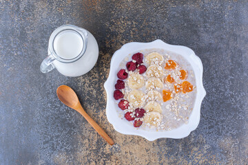 Muesli porridge with raspberries and a jar of milk