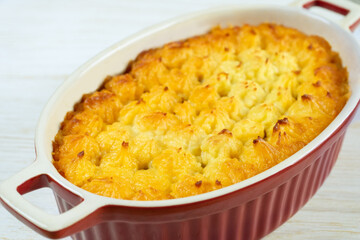 Shepherd's pie or Cottage pie. Minced meat, mashed potatoes and vegetables casserole on white wooden background. Traditonal British, United Kingdom, Ireland cuisine. Close up view