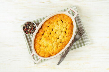 Shepherd's pie or Cottage pie. Minced meat, mashed potatoes and vegetables casserole on white wooden background. Traditonal British, United Kingdom, Ireland cuisine. Top view, flat lay