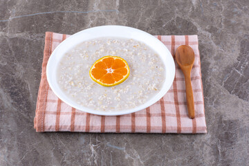 Milky porridge with an orange slice on the top
