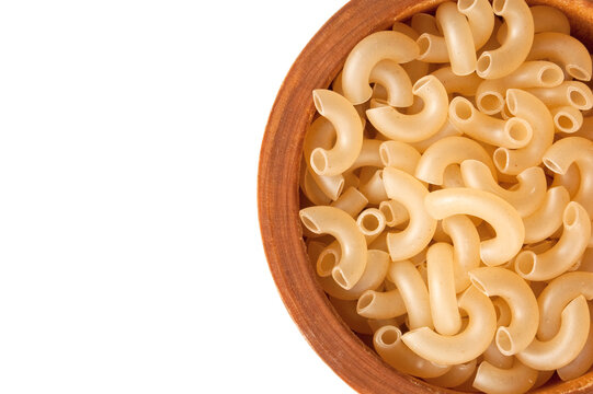 Uncooked pasta on the wooden bowl on a white background