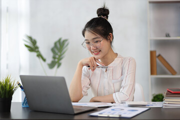 Asian woman working on laptop in home office and online seminar via laptop.