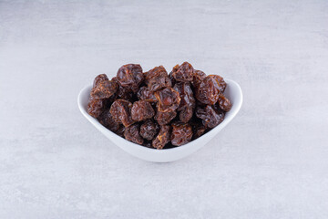 Dried sour cherries in a cup on concrete background