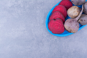Whole and sliced beetroots in a blue platter