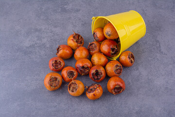 Medlars isolated on the concrete background