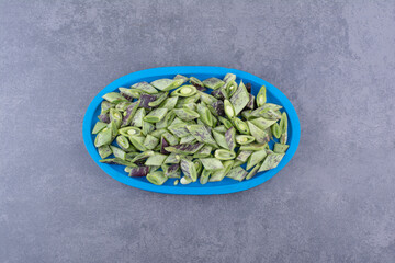 Green beans inside a container or platter on concrete background