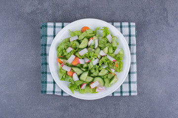 Vegetable salad with mixed ingredients on a checked kitchen towel
