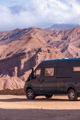 Fototapeta na wymiar Campervan 4x4 in a route with red mountains at La Quebrada las Conchas in Argentina.