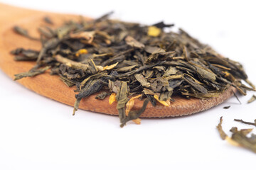 Fototapeta na wymiar aromatic green dry tea on a wooden spoon, isolated on white background
