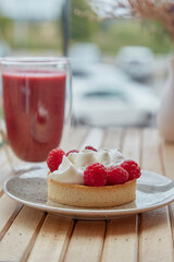 Aesthetic healthy autumn lunch - pink strawberry smoothie and french tart on the wooden table