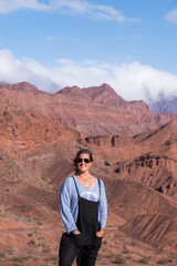 Portrait of woman on top of a red mountain in Quebrada de las Conchas Argentina.