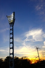 Lighting mast of football soccer stadium at sunset