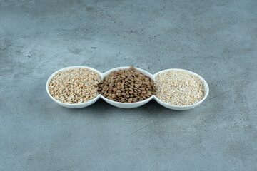 Sunflower and pumpkin seeds with rice grains in white cups