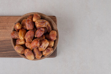 Yellow dry dates isolated on a wooden platter