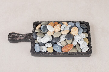 Multicolor beach stones isolated on concrete background